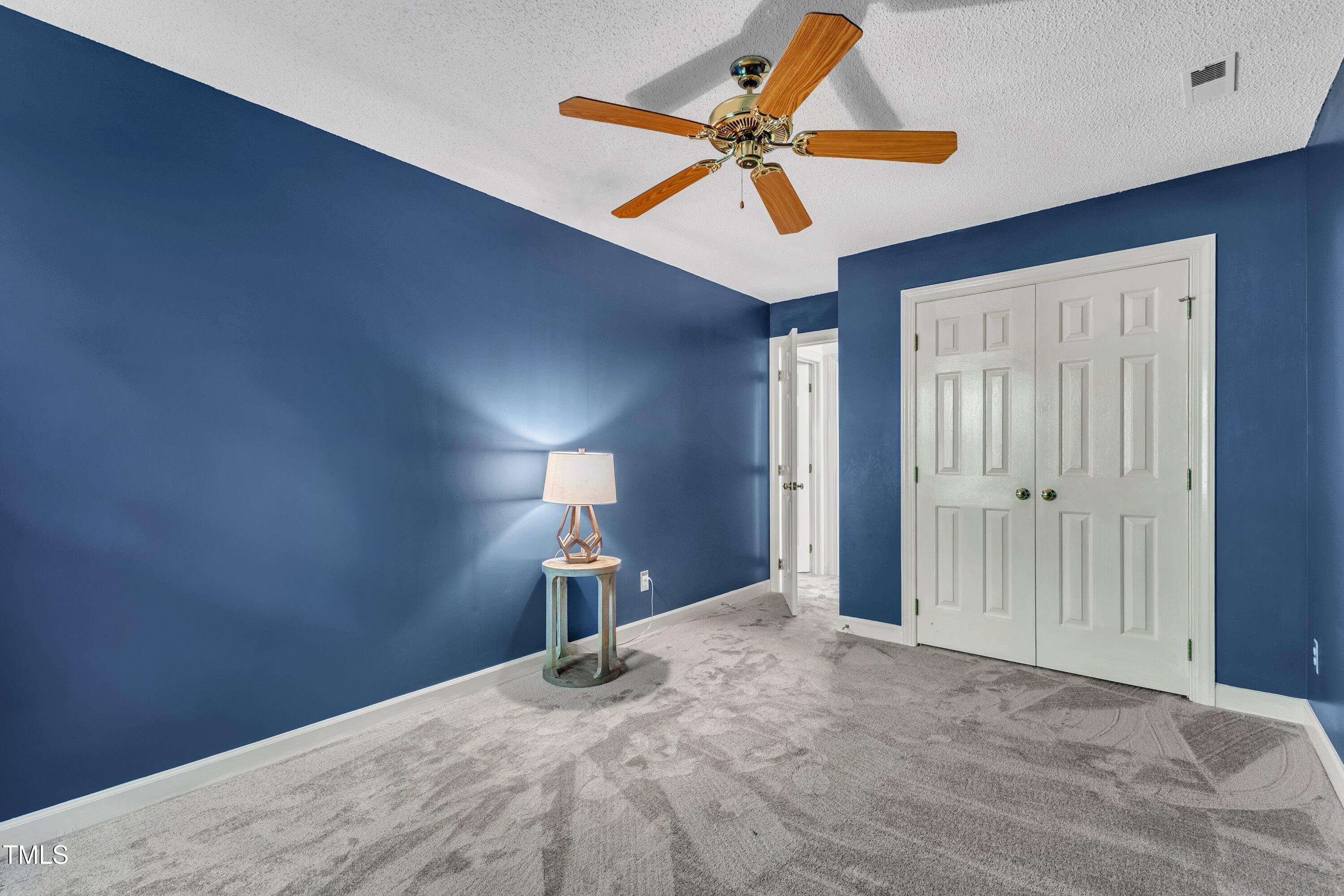 1210 Shadow Bark Court Raleigh, NC 27603 - Photo 19 of 32 a bedroom with a bed and a chandelier