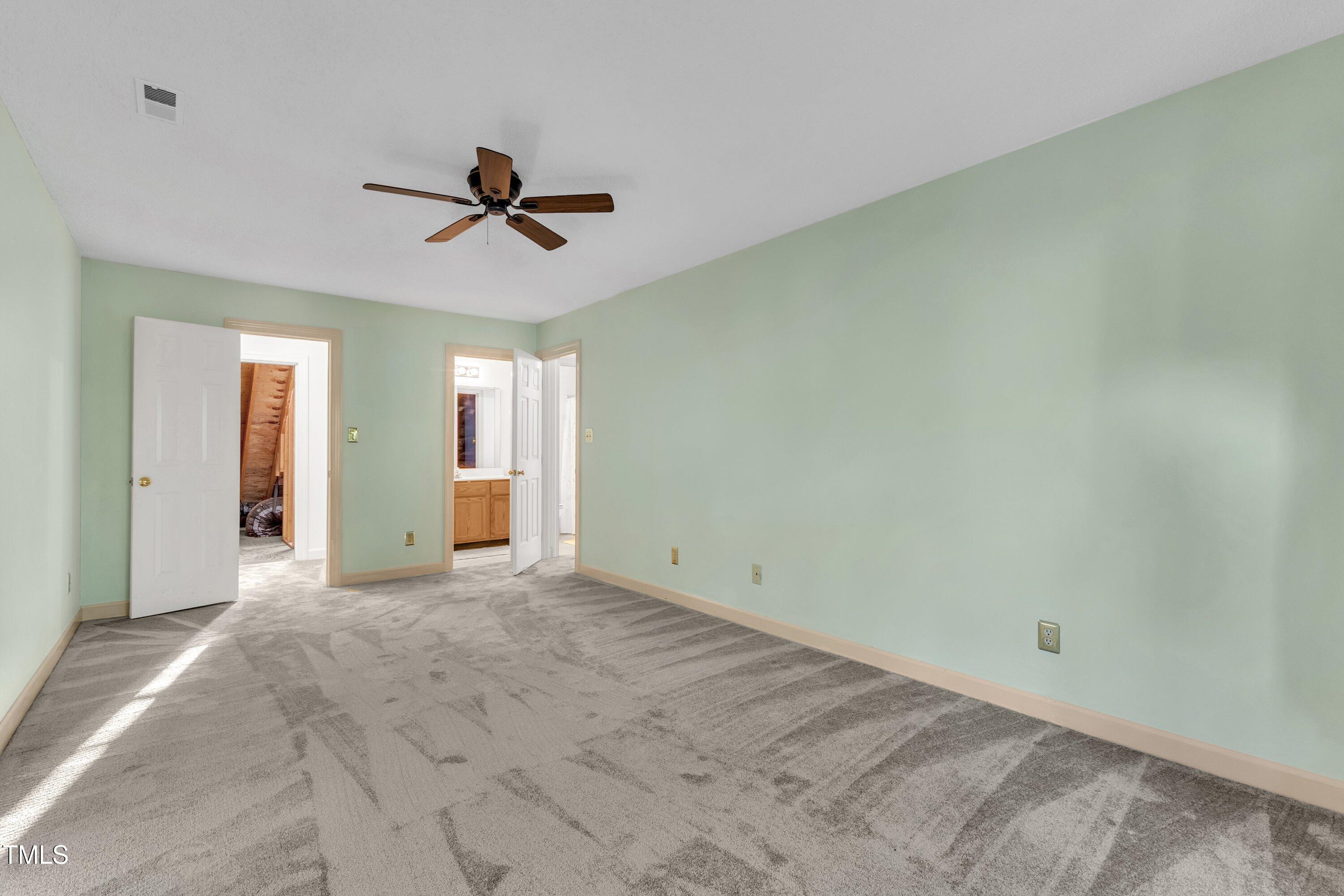1210 Shadow Bark Court Raleigh, NC 27603 - Photo 21 of 32 an empty room with chandelier fan and windows