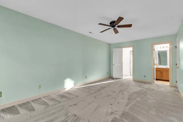 a view of a room with a ceiling fan and window