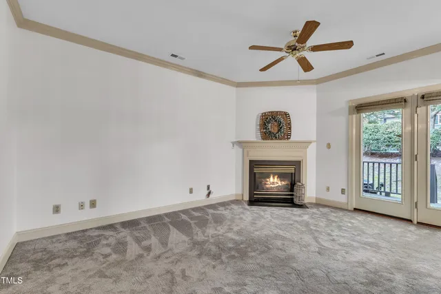 a view of an empty room with a fireplace and a window