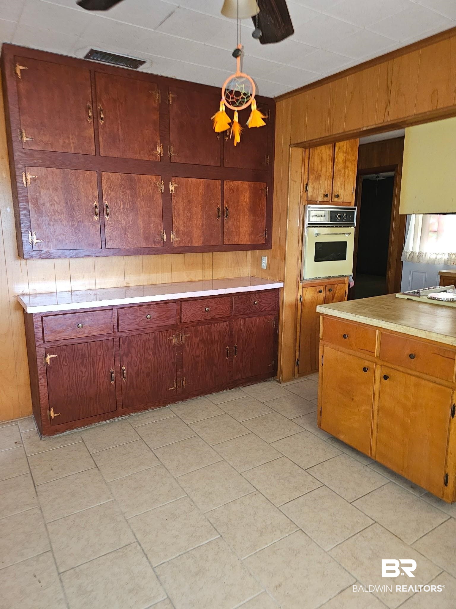 304 Sutherland Drive Mobile, AL 36611 - Photo 6 of 18 Kitchen with ceiling fan, oven, stainless steel gas stovetop, and wood walls