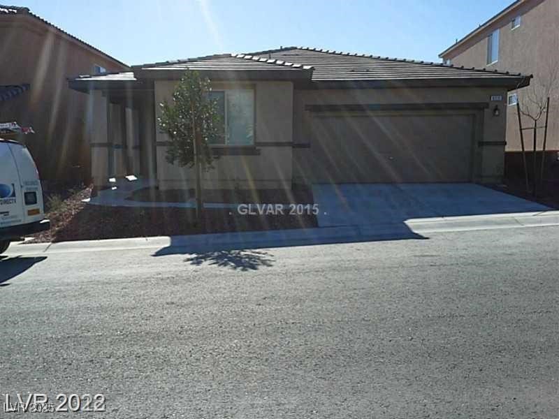View of front of property with a tiled roof, a garage, and concrete driveway