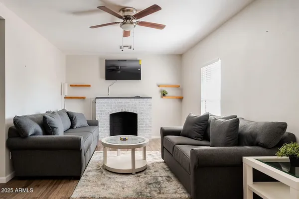 a living room with furniture a fireplace and a flat screen tv