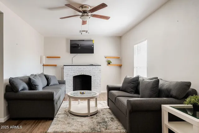 a living room with furniture a fireplace and a flat screen tv