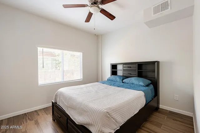 a bedroom with a bed and wooden floor