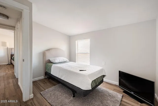 a bedroom with a bed and wooden floor