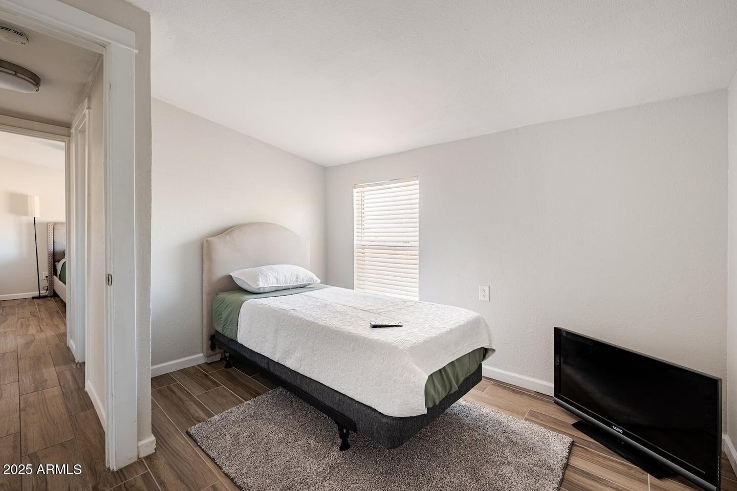 1514 East Fillmore Street Phoenix, AZ 85006 - Photo 22 of 24 a bedroom with a bed and wooden floor