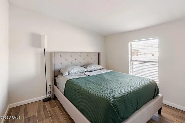 a bedroom with a bed and wooden floor