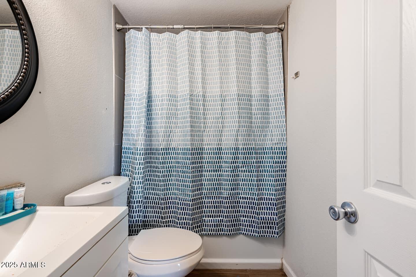 1514 East Fillmore Street Phoenix, AZ 85006 - Photo 24 of 24 a white toilet sitting next to a shower curtain