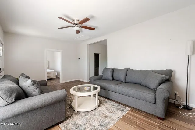 a living room with furniture a ceiling fan and a rug