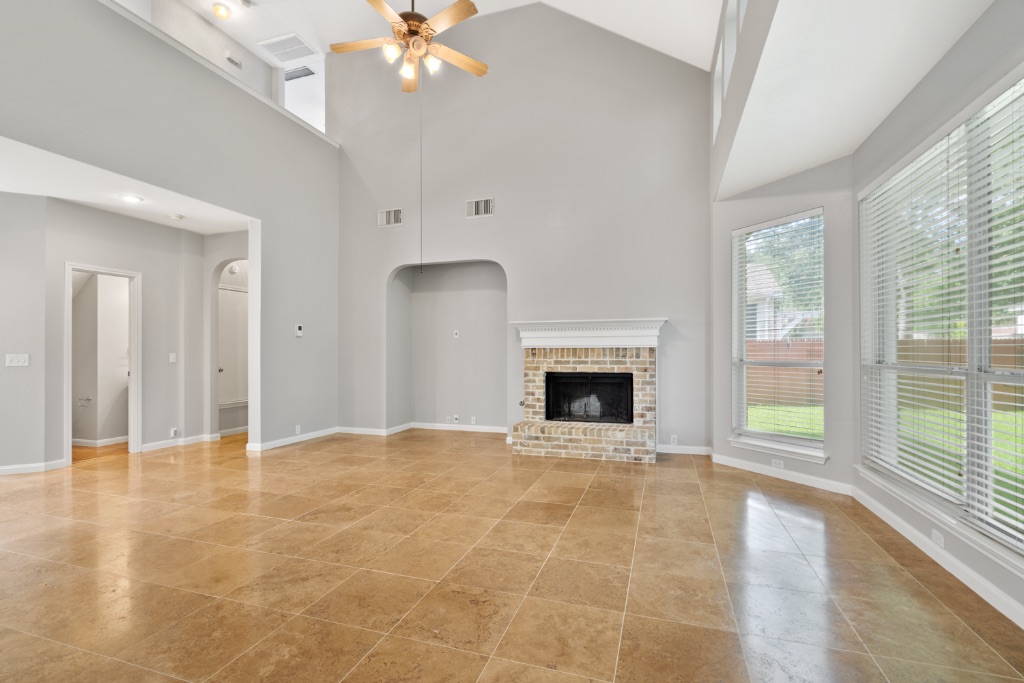 a view of an empty room with a fireplace and a window