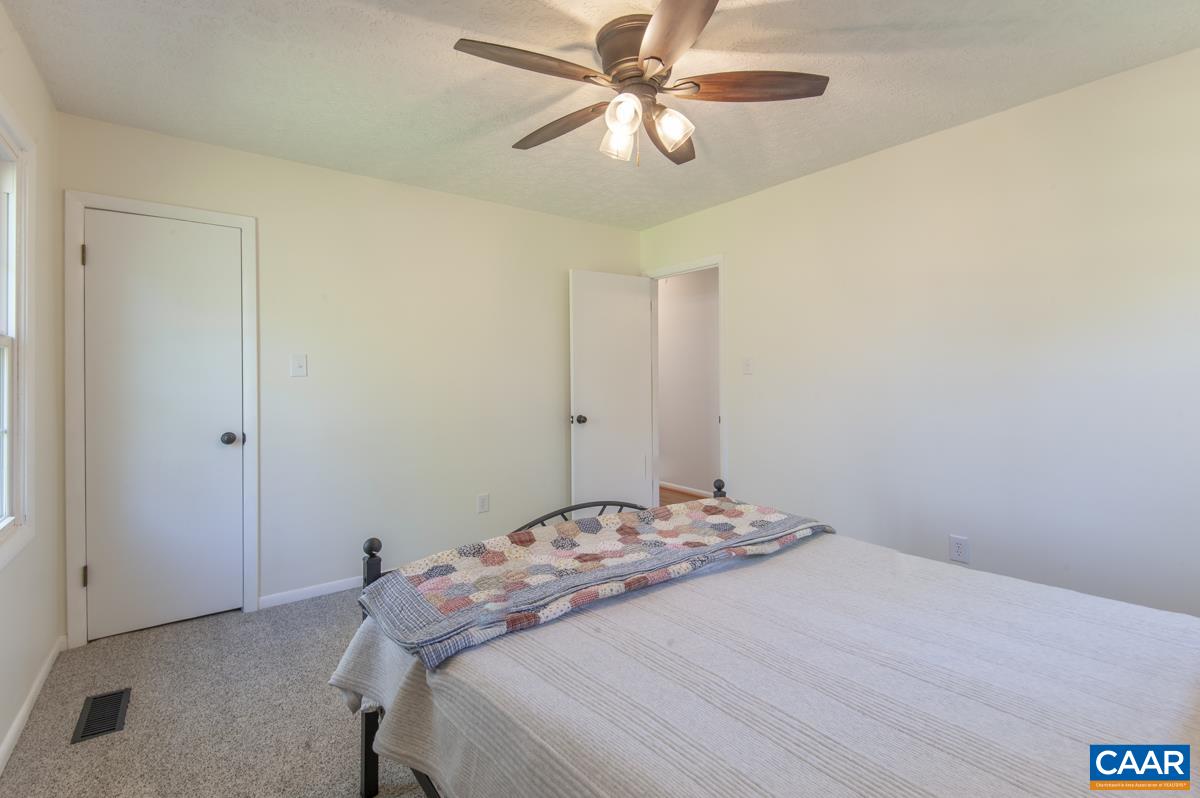 8882 James River Road Shipman, VA 22971 - Photo 17 of 50 a bedroom with a bed and a chandelier fan