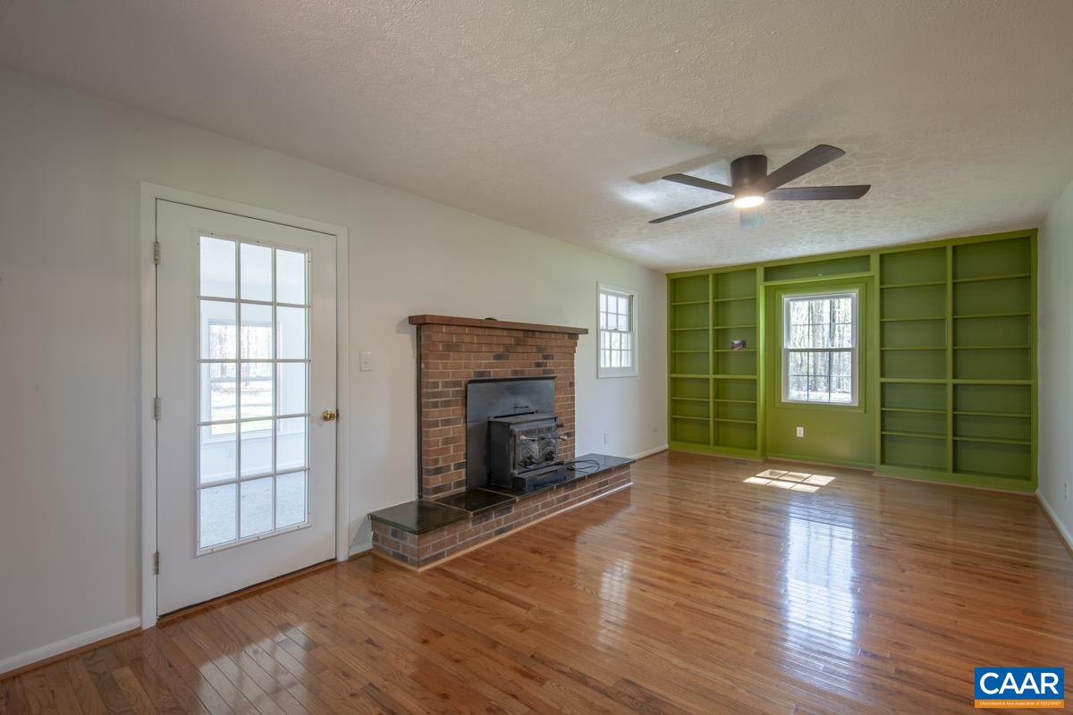 8882 James River Road Shipman, VA 22971 - Photo 21 of 50 a view of an empty room with window wooden floor and fire place