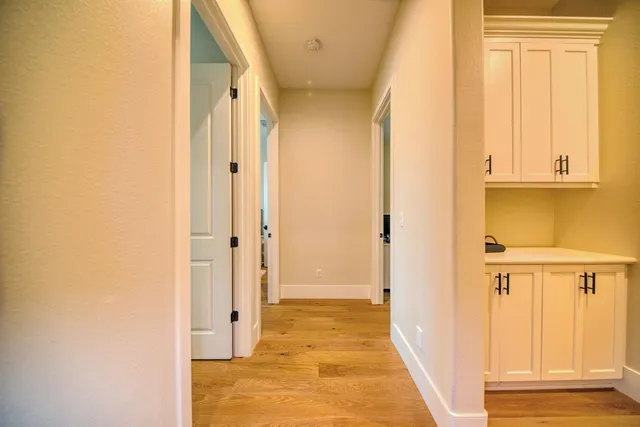 a view of a hallway with wooden door and wooden door
