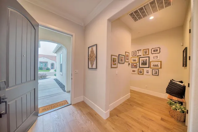a view of a hallway with workspace and wooden floor