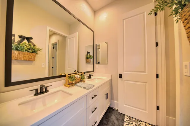 a spacious bathroom with a double vanity sink a mirror and shower