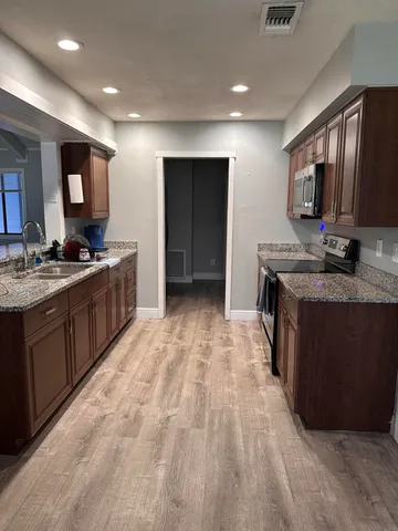 a kitchen with stainless steel appliances granite countertop a sink stove and cabinets