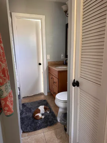 a bathroom with a granite countertop toilet and a shower