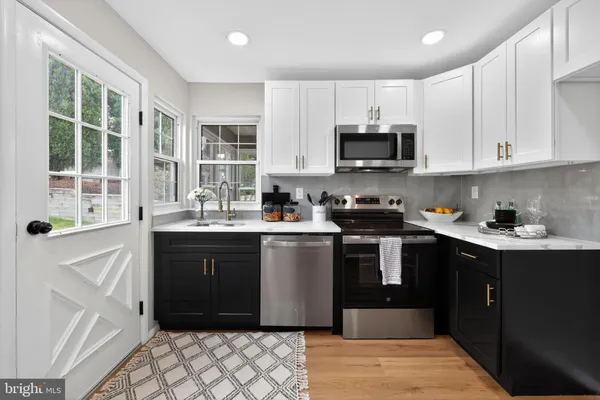 a kitchen with stainless steel appliances granite countertop a refrigerator and a sink