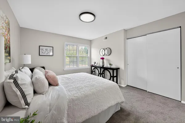 a bed sitting in a bedroom next to a window