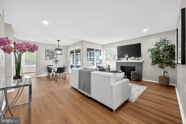 a living room with furniture a fireplace and a potted plant