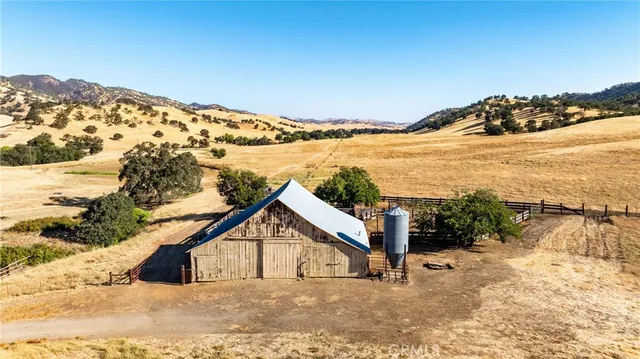 a view of a dry yard covered with snow in the background