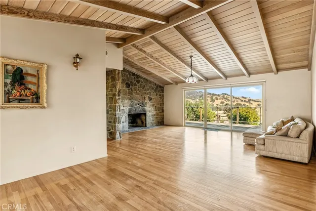 a view of empty room with wooden floor and fireplace