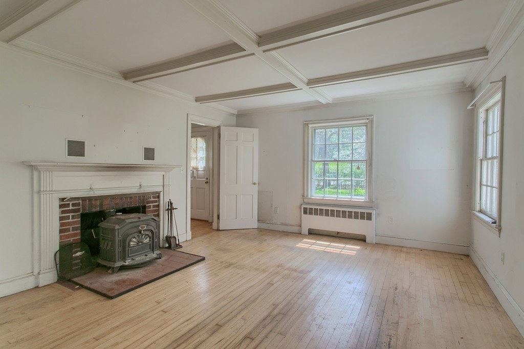 335 Ayer Road Harvard, MA 01451 - Photo 9 of 22 a view of an empty room with wooden floor fireplace and a window
