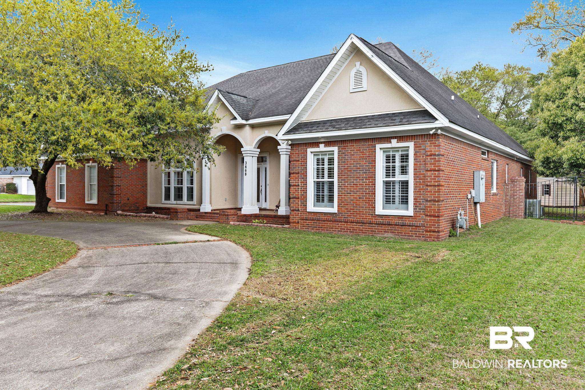3668 Claridge Road North Mobile, AL 36608 - Photo 3 of 100 View of front of home featuring a shingled roof, brick siding, stucco siding, and driveway