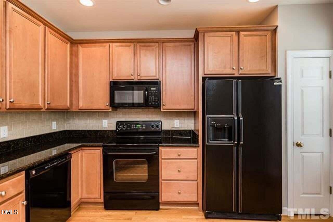 1216 Colonial Club Road Wake Forest, NC 27587 - Photo 11 of 26 a kitchen with granite countertop a refrigerator stove and microwave
