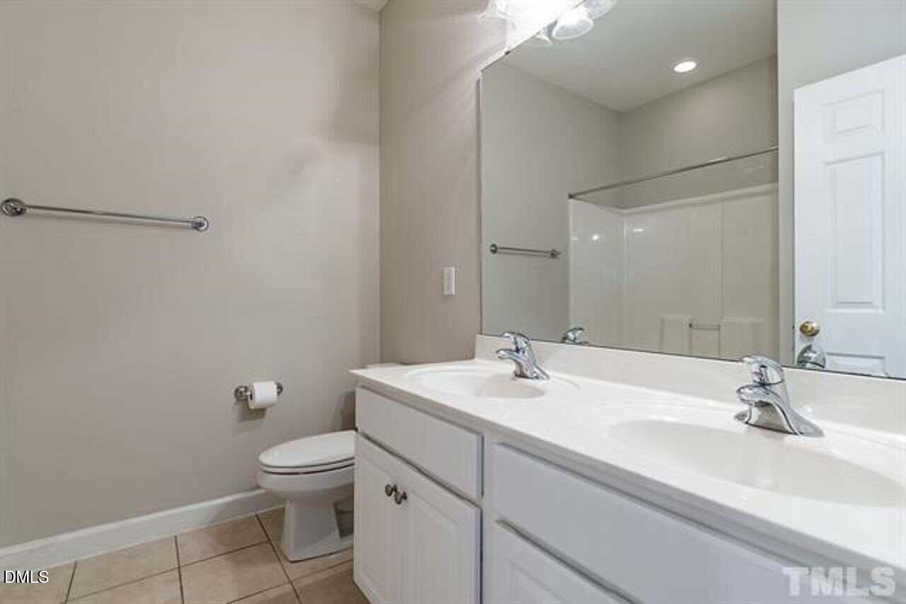 1216 Colonial Club Road Wake Forest, NC 27587 - Photo 22 of 26 a bathroom with a sink a toilet and mirror