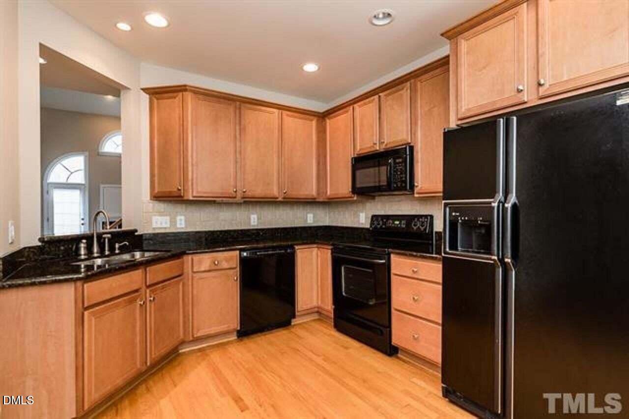 1216 Colonial Club Road Wake Forest, NC 27587 - Photo 7 of 26 a kitchen with stainless steel appliances granite countertop a stove a sink dishwasher a refrigerator and a microwave oven