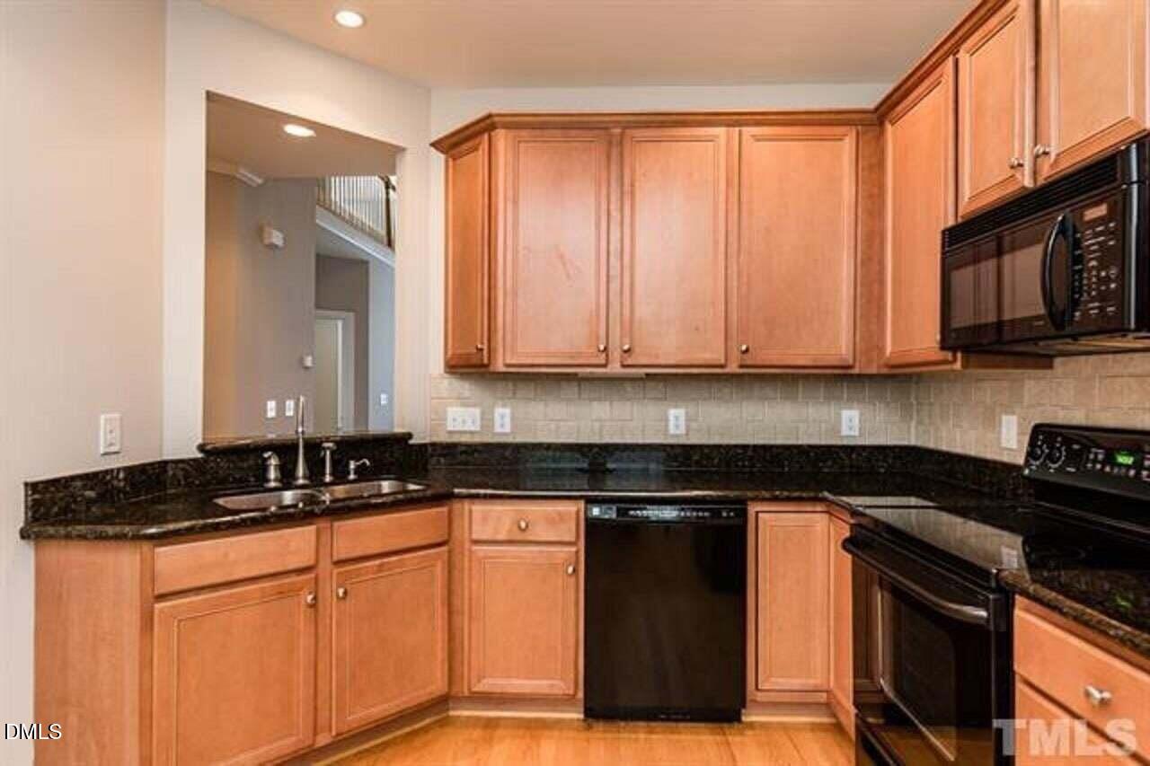 1216 Colonial Club Road Wake Forest, NC 27587 - Photo 8 of 26 a kitchen with stainless steel appliances granite countertop a stove a sink and a microwave