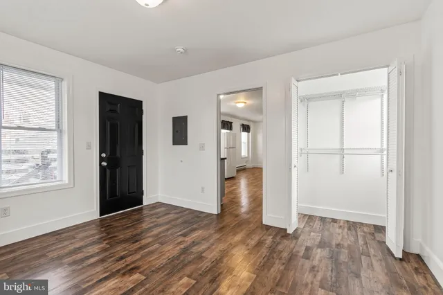an empty room with wooden floor and windows