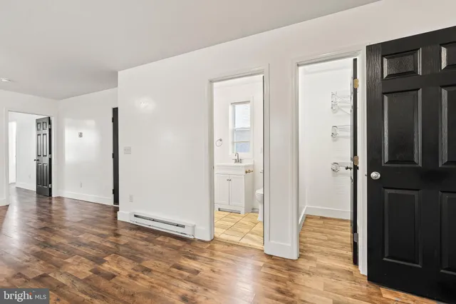 a view of a hallway with wooden door and entryway