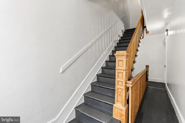 a view of staircase with wooden floor and white walls