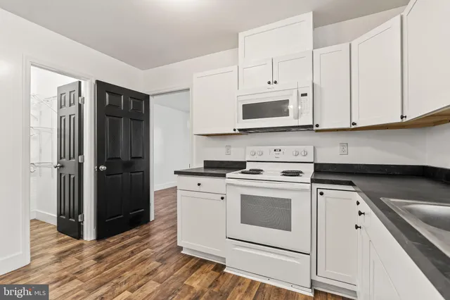 a kitchen with cabinets appliances and a wooden floor