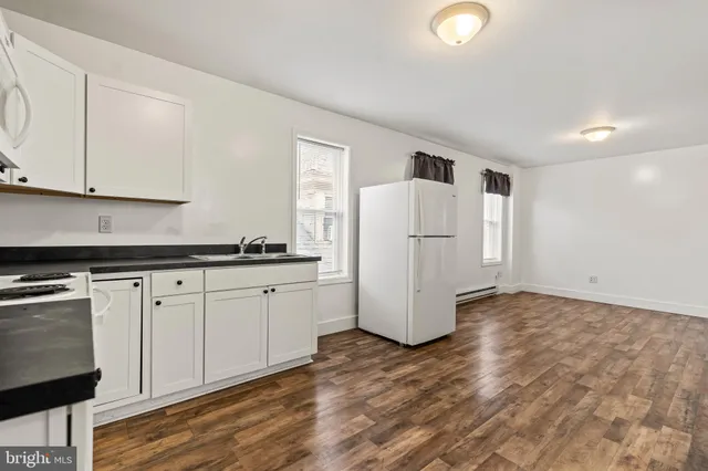 a kitchen with a refrigerator sink and cabinets