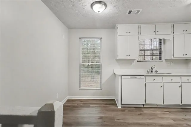 a kitchen with granite countertop white cabinets and white appliances