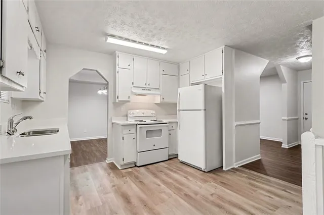 a view of an empty room with wooden floor fireplace and a window