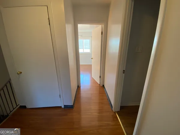 a view of a hallway with wooden floor