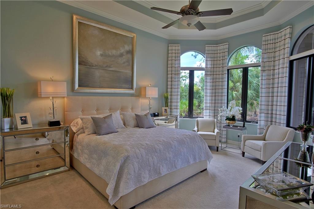 7389 Byrons Way Naples, FL 34113 - Photo 16 of 35 a bedroom with a large bed and a chandelier