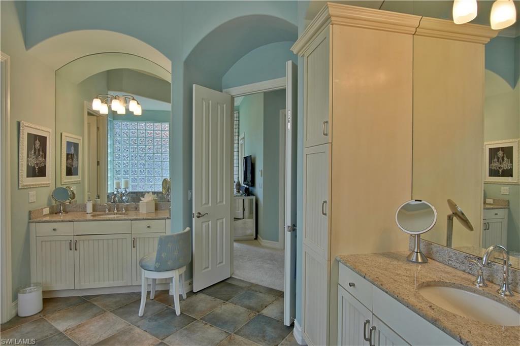 7389 Byrons Way Naples, FL 34113 - Photo 18 of 35 a bathroom with a granite countertop sink a toilet and a mirror