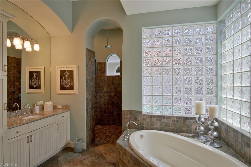 7389 Byrons Way Naples, FL 34113 - Photo 19 of 35 a bathroom with a granite countertop sink a toilet and shower