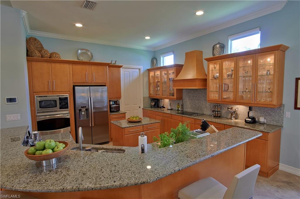 7389 Byrons Way Naples, FL 34113 - Photo 20 of 35 a kitchen with stainless steel appliances granite countertop a sink a stove and a refrigerator