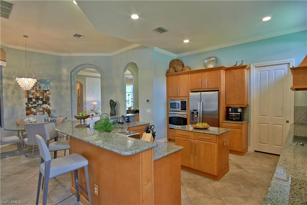 7389 Byrons Way Naples, FL 34113 - Photo 23 of 35 a room with stainless steel appliances lots of counter space and dining table