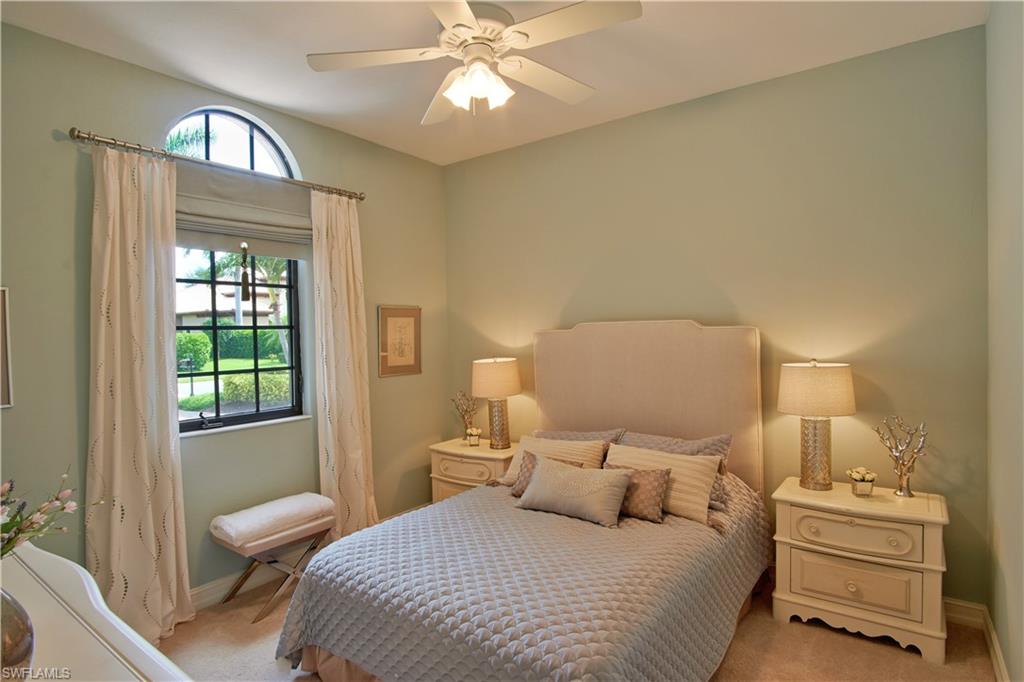 7389 Byrons Way Naples, FL 34113 - Photo 28 of 35 a bedroom with a bed and a chandelier