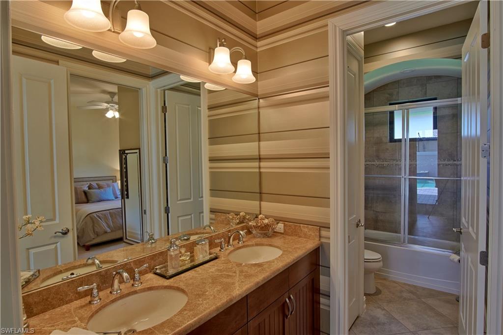 7389 Byrons Way Naples, FL 34113 - Photo 29 of 35 a bathroom with a granite countertop sink and a mirror