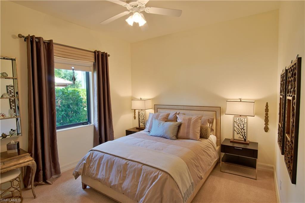 7389 Byrons Way Naples, FL 34113 - Photo 30 of 35 a bedroom with a bed and a large mirror