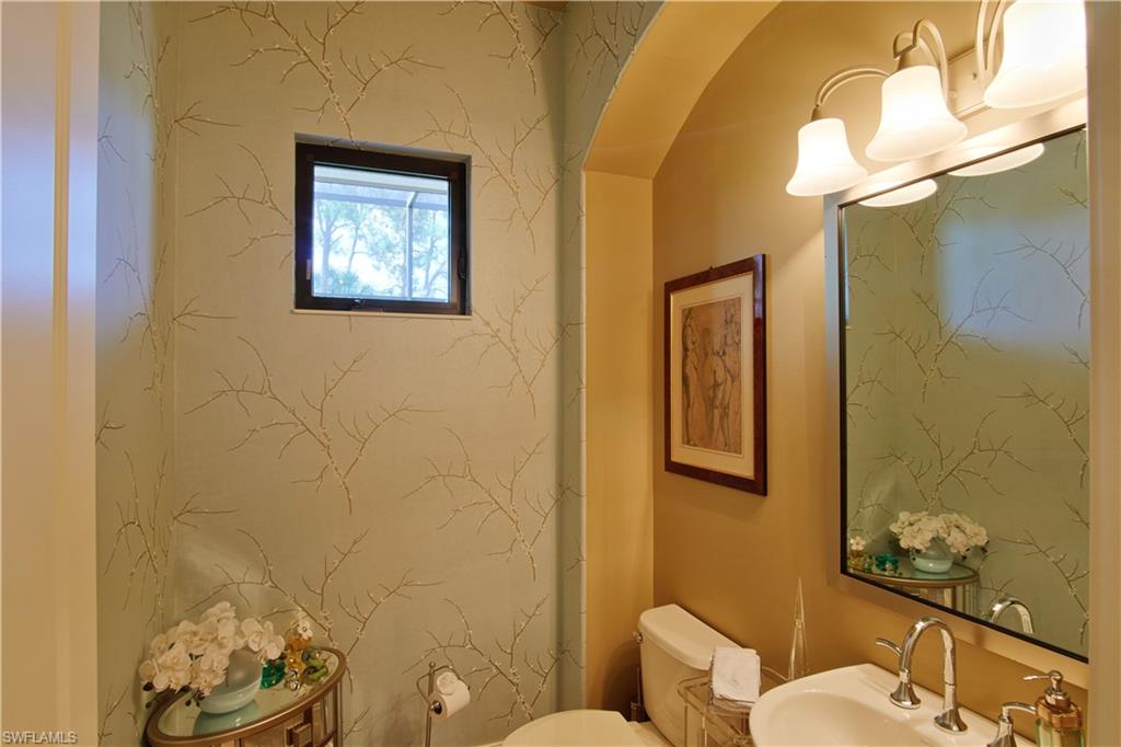 7389 Byrons Way Naples, FL 34113 - Photo 31 of 35 a bathroom with a toilet sink and mirror